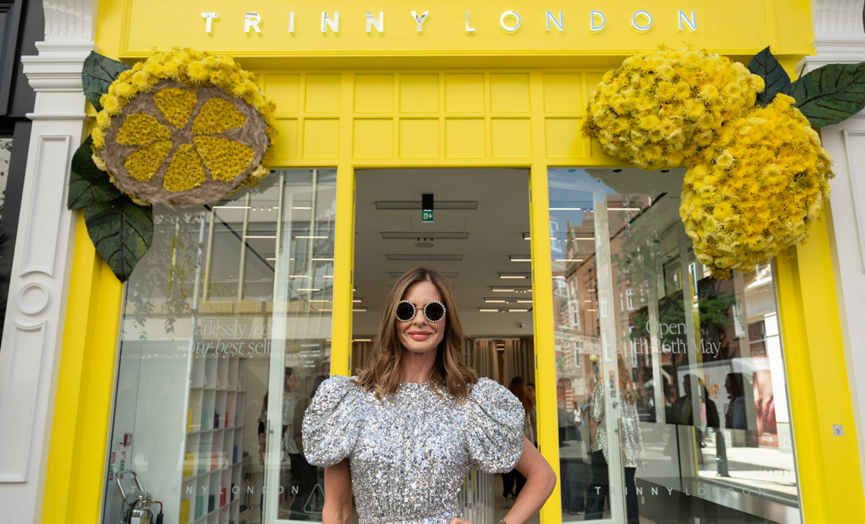 trinny woodall in front of a trinny london store