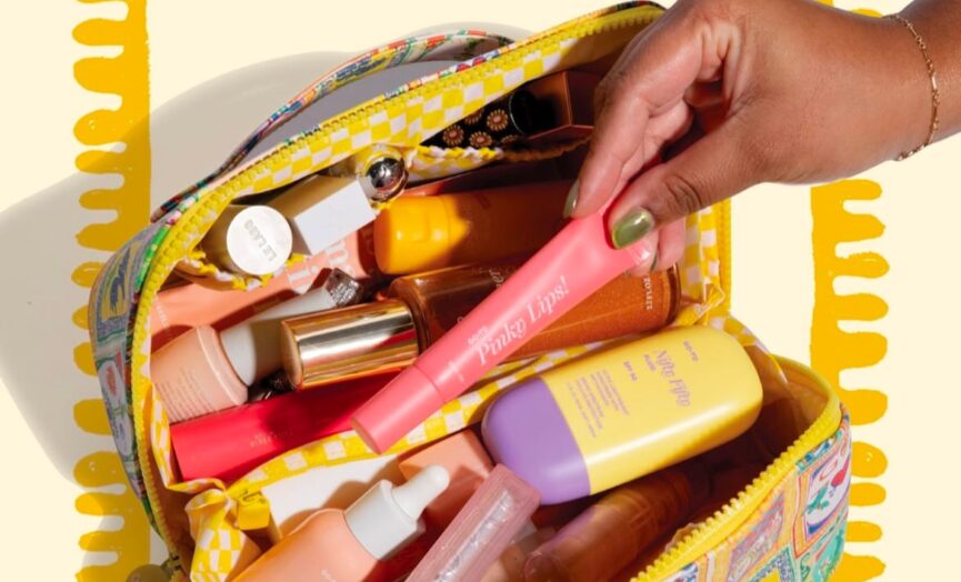 Hand reaching into makeup bag filled with products